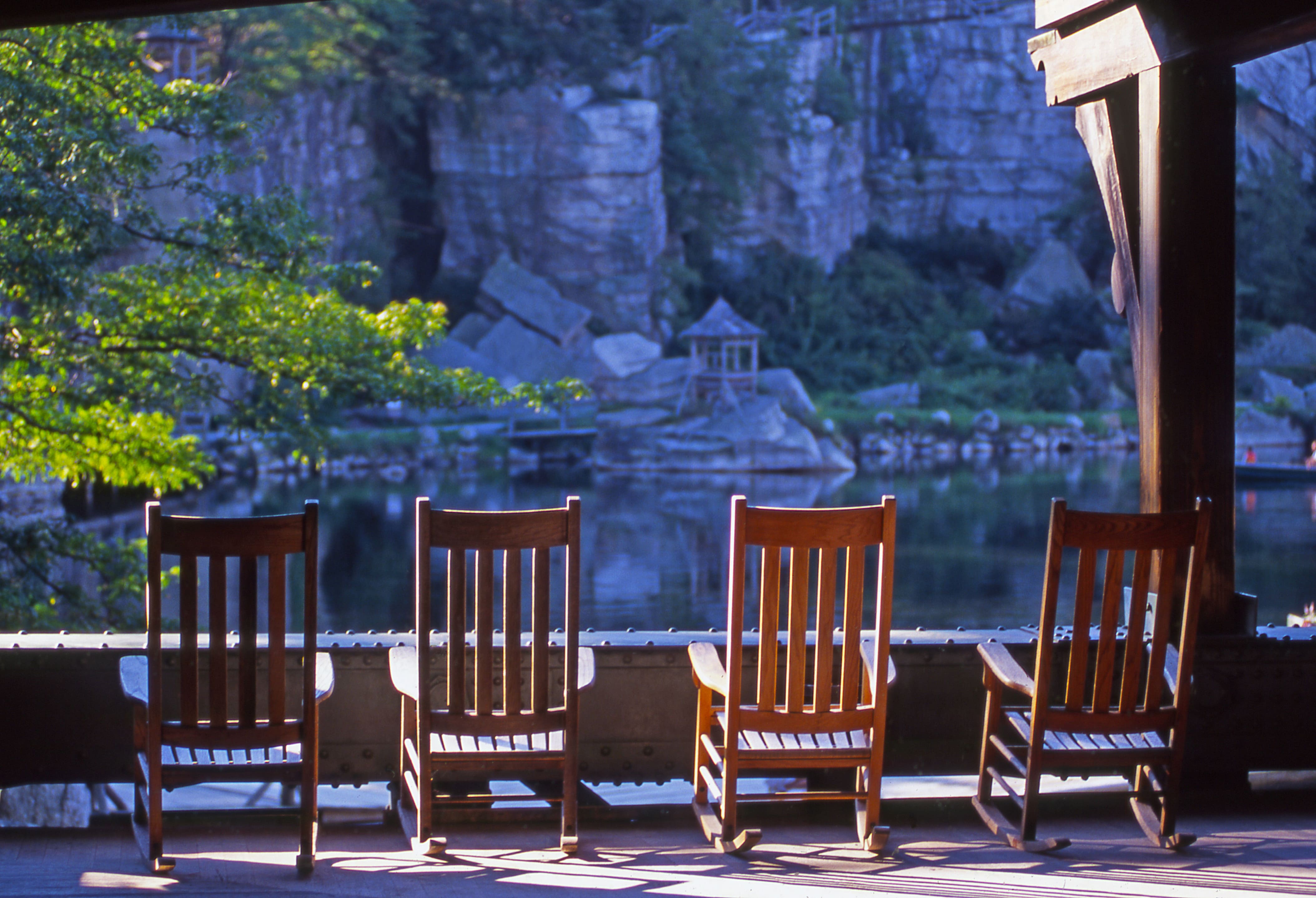 a row of wooden chairs by a lake
