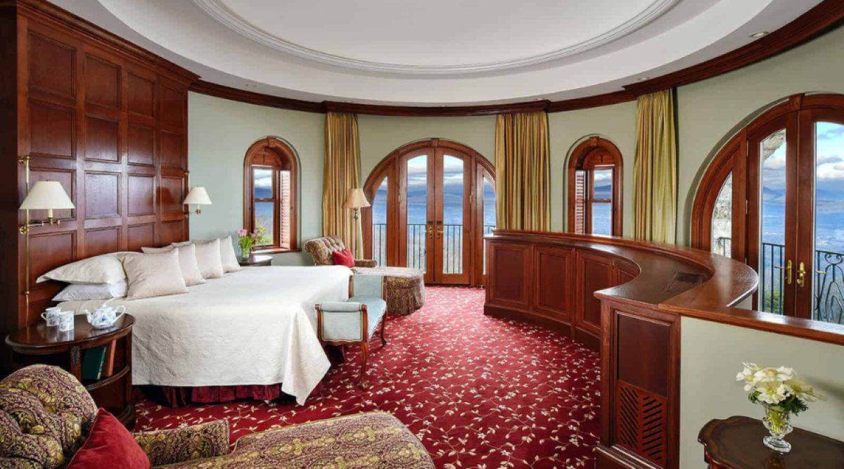 a room with a round bed and chairs