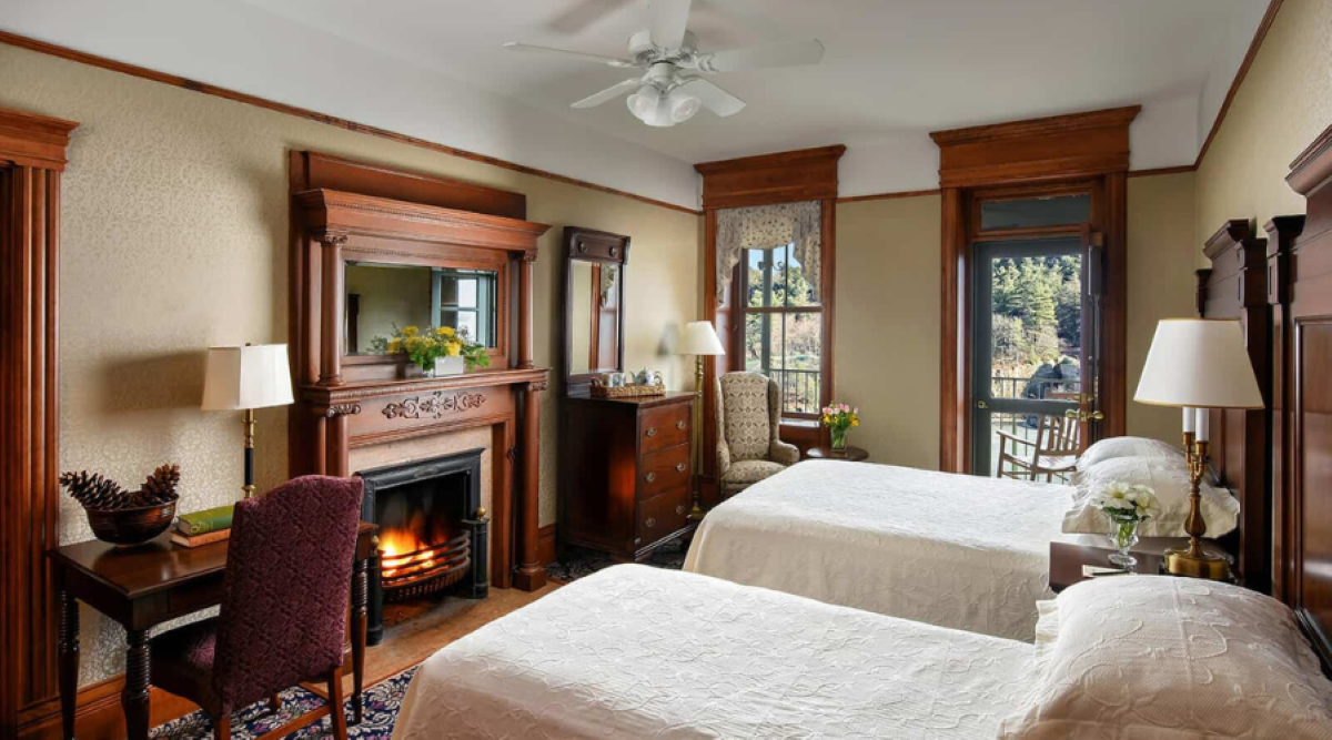 a room with two beds and a fireplace