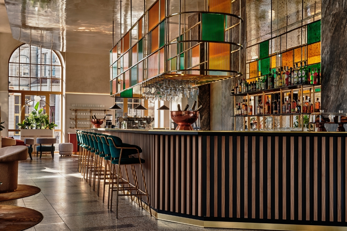a bar with a bar stools and a glass chandelier