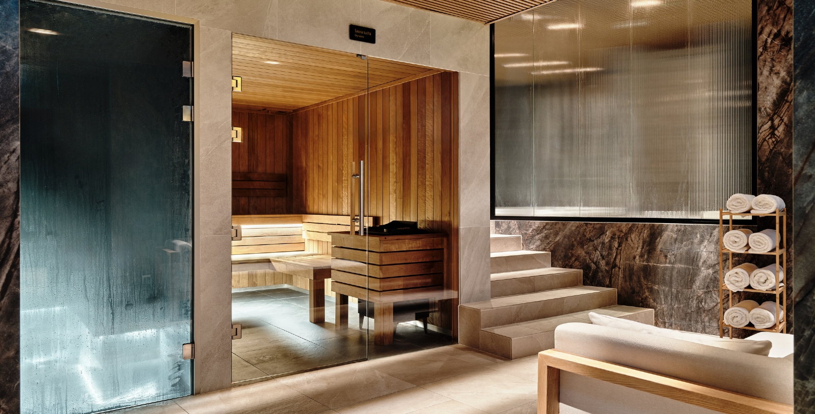 a glass door in a room with a wooden bench and stairs
