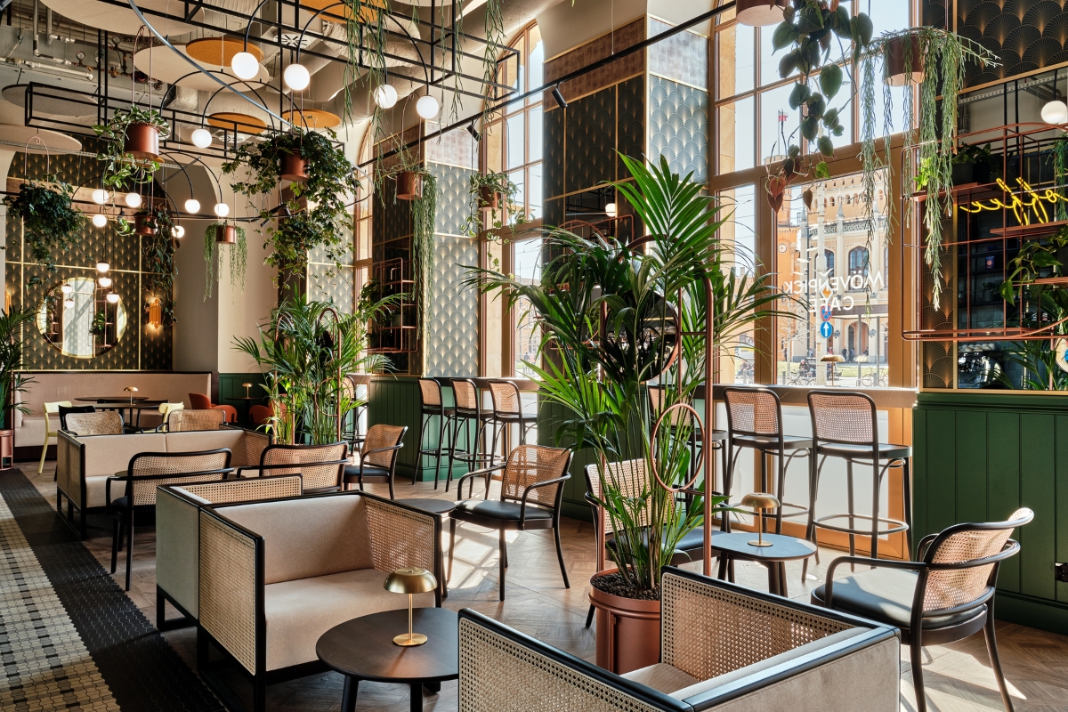 a room with tables and chairs and plants