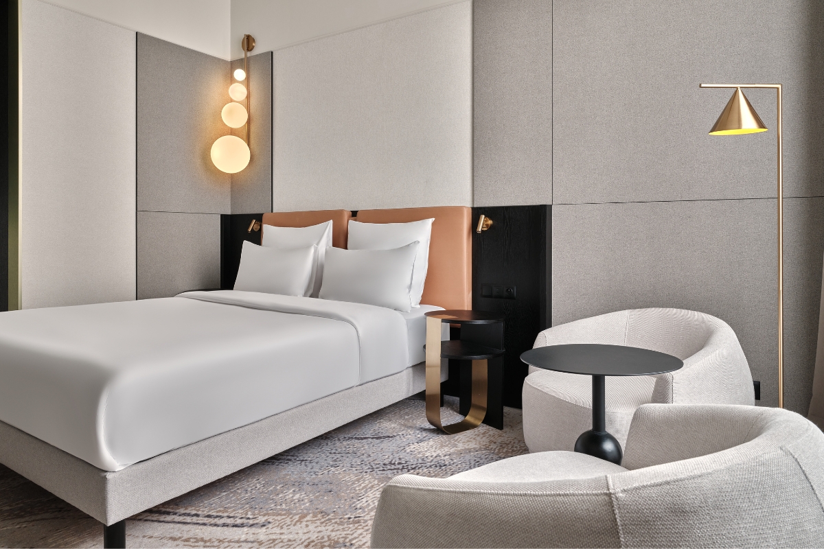 a bed with white sheets and a round table
