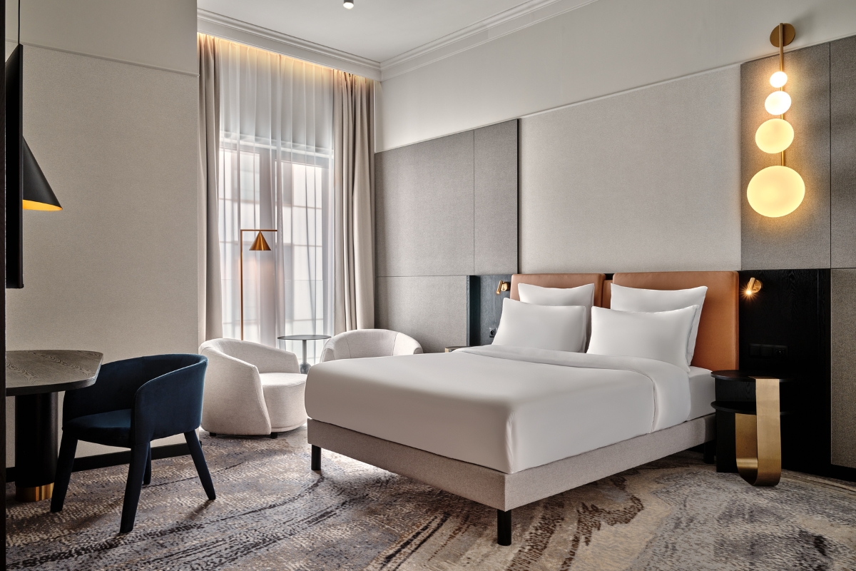 a room with a bed and chairs
