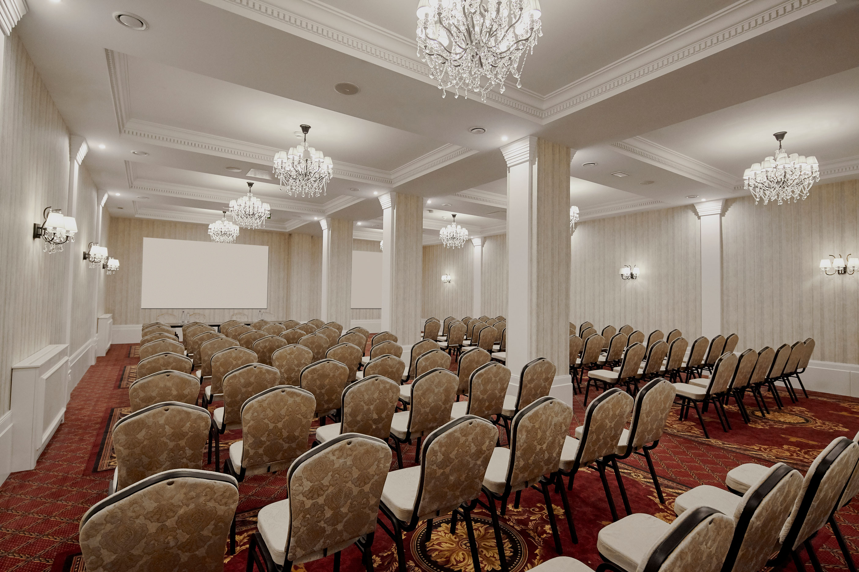 a room with chairs and chandeliers