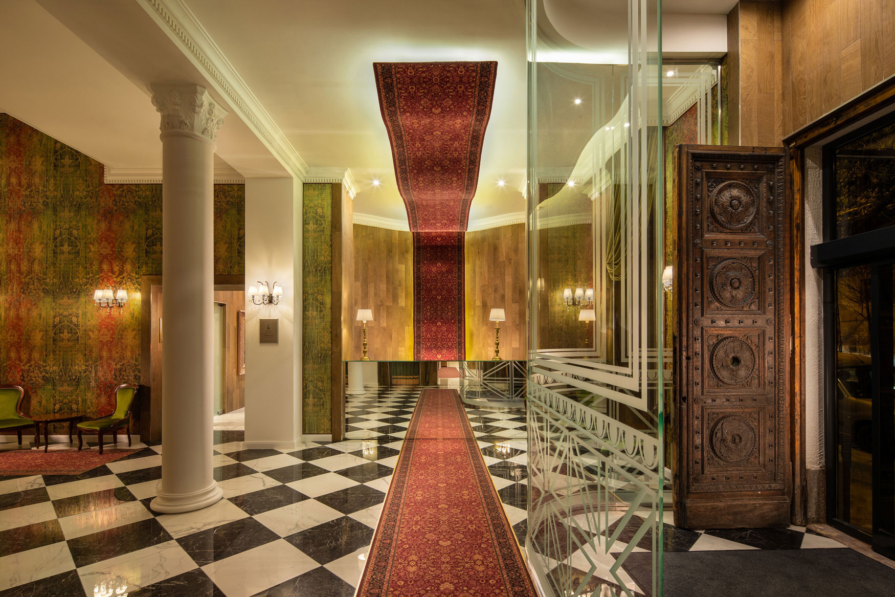 a hallway with a red carpet and a black and white checkered floor