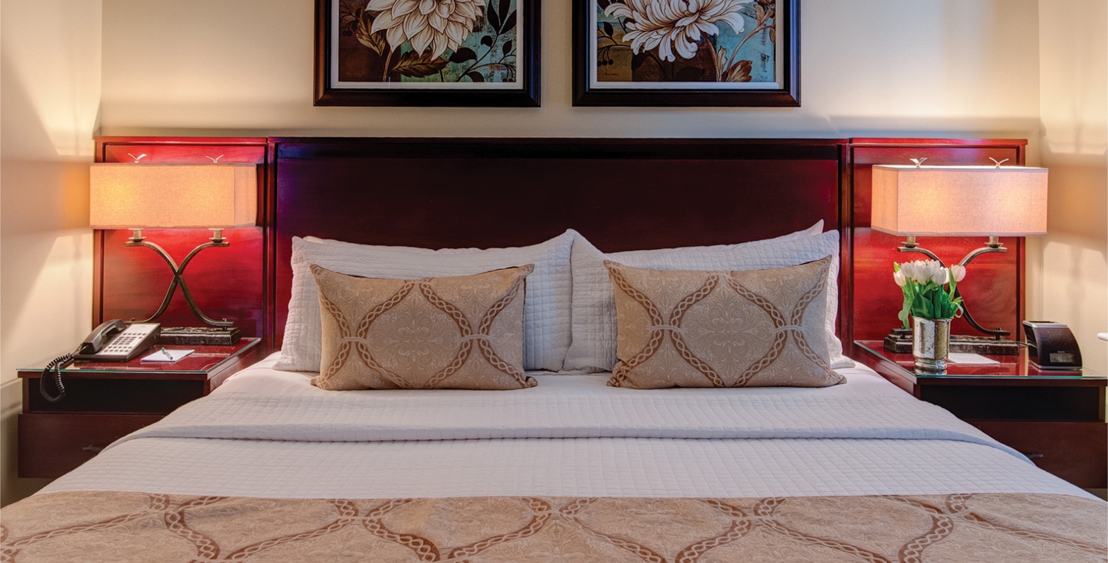 a bed with pillows and a picture on the wall