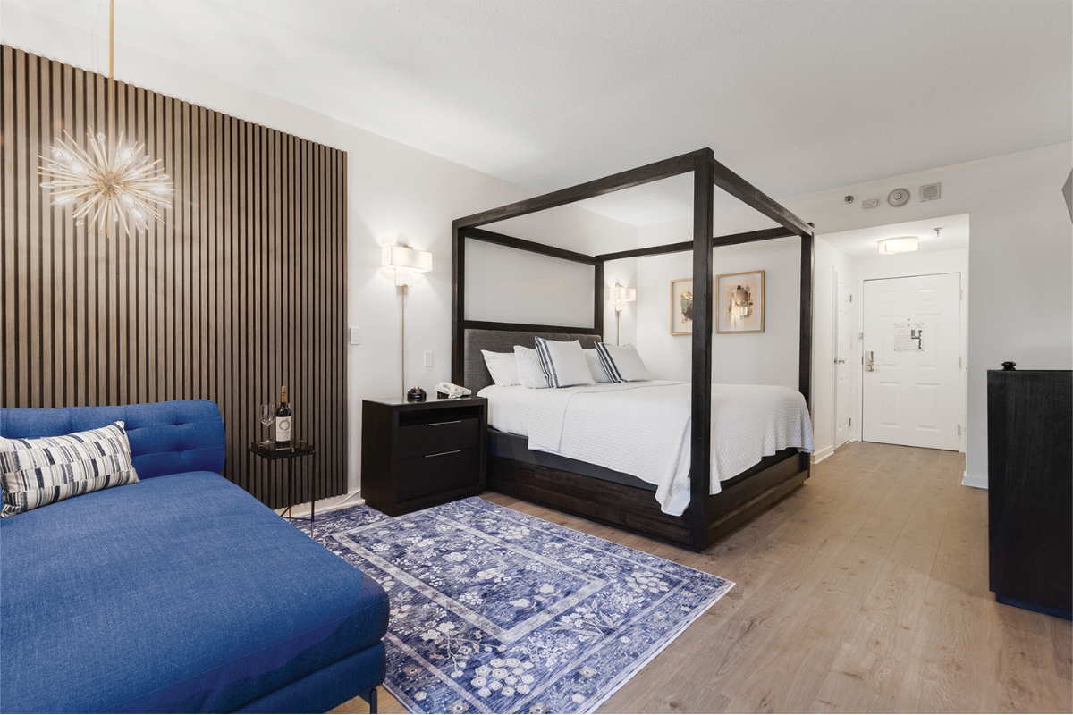 a bedroom with a blue couch and a bed
