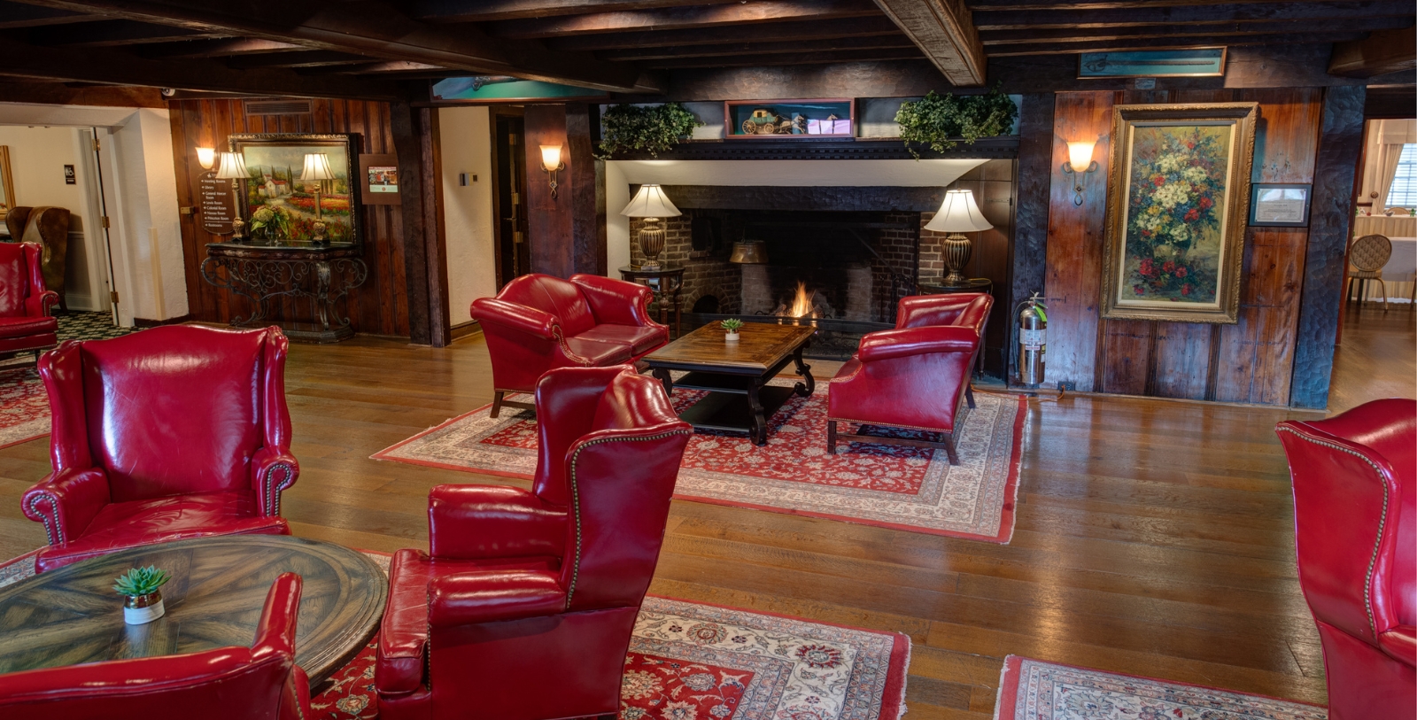 a room with red chairs and a fireplace