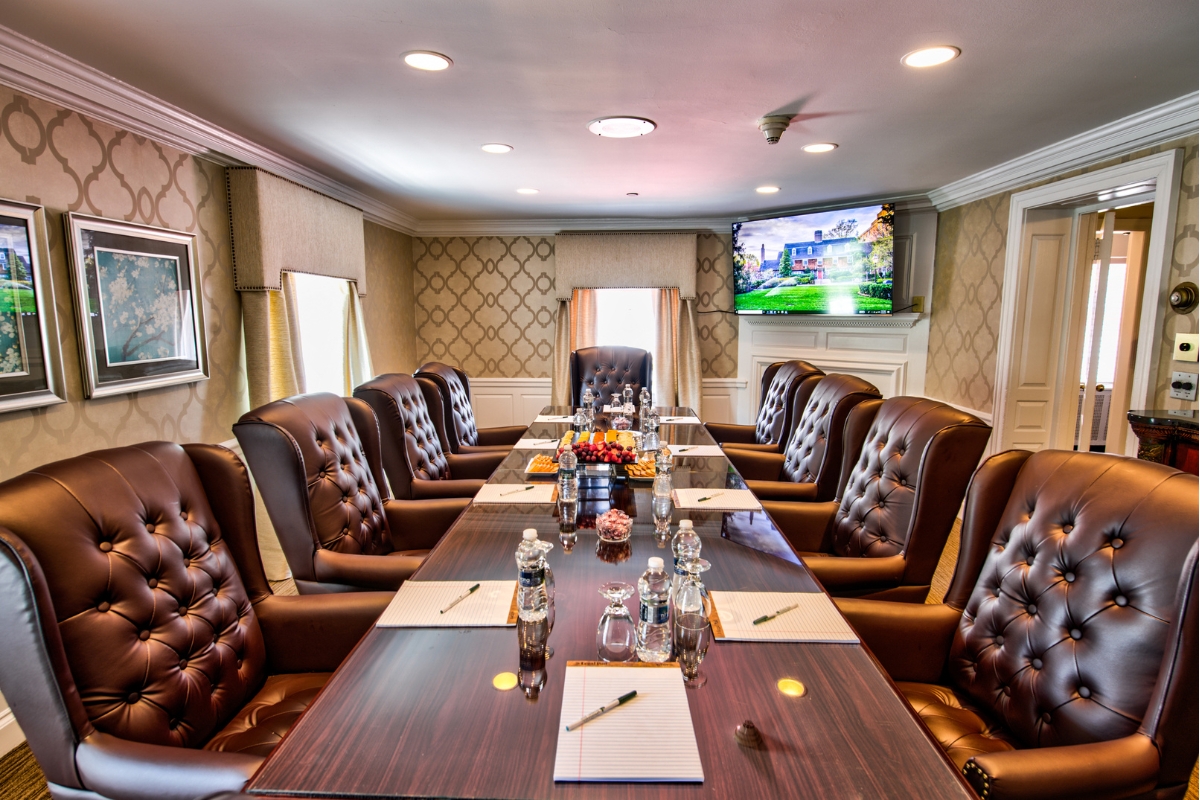 a conference room with leather chairs and a table with food on it
