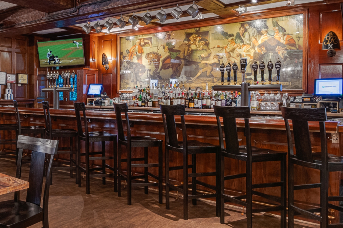 a bar with a row of beer taps and a painting on the wall