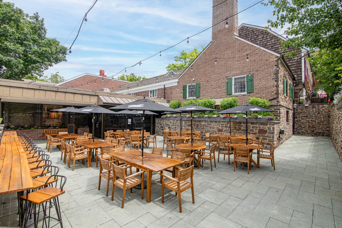 a patio with tables and chairs and umbrellas