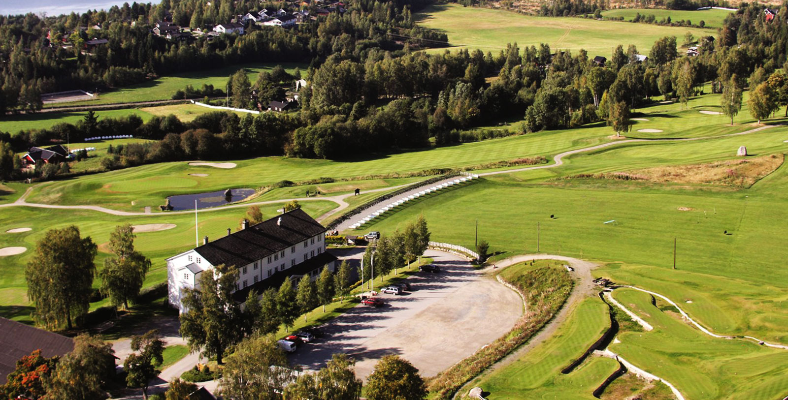 a large golf course with a building and a parking lot