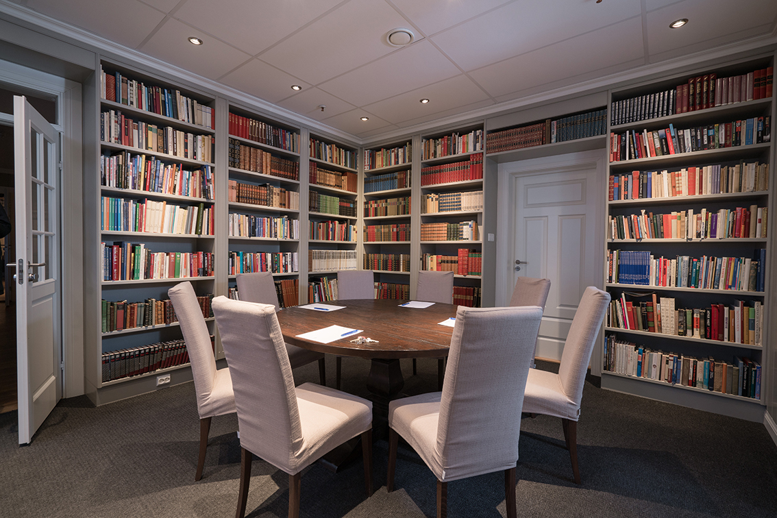 a room with a table and chairs in front of bookshelves