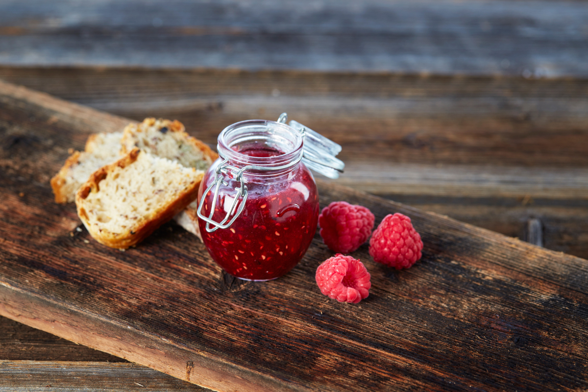 a jar of raspberry jam and bread