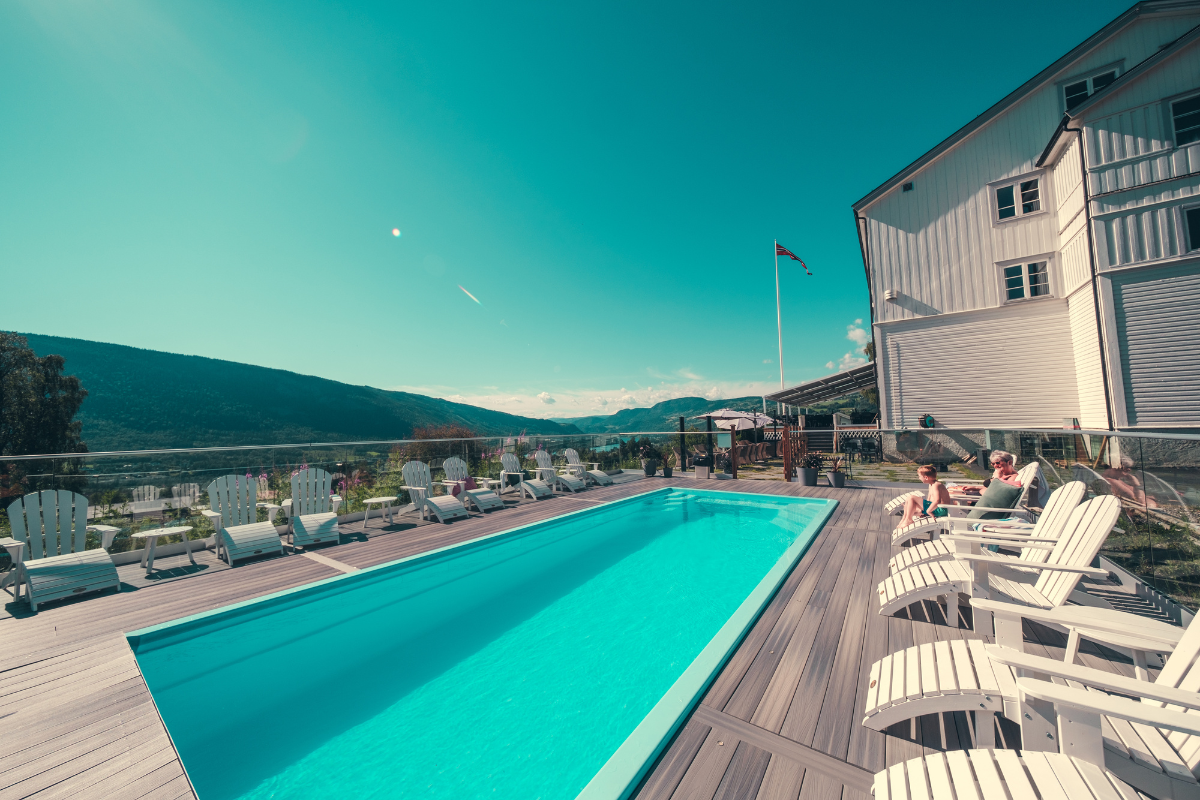 a pool with chairs and a building in the background