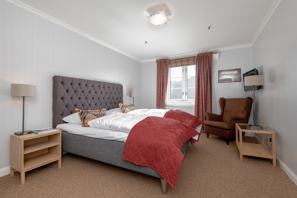 a bedroom with a bed and chairs