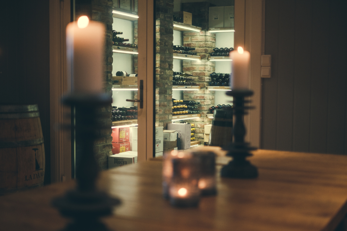 candles on a table with a wine rack in the background