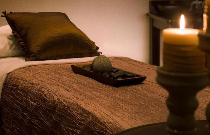 a bed with a candle and a tray of rocks