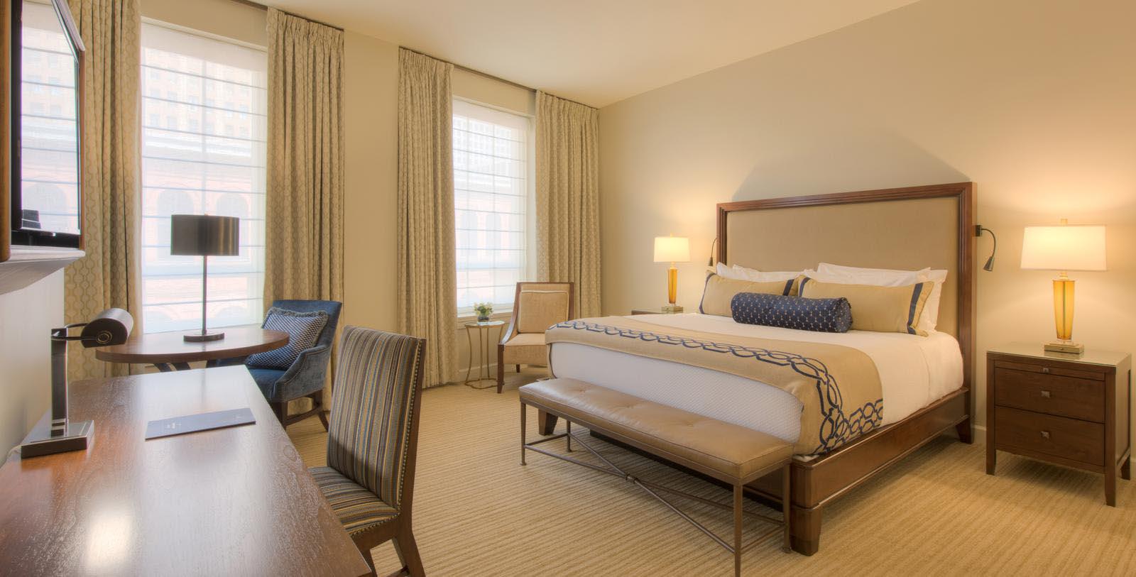 a room with a bed and chairs
