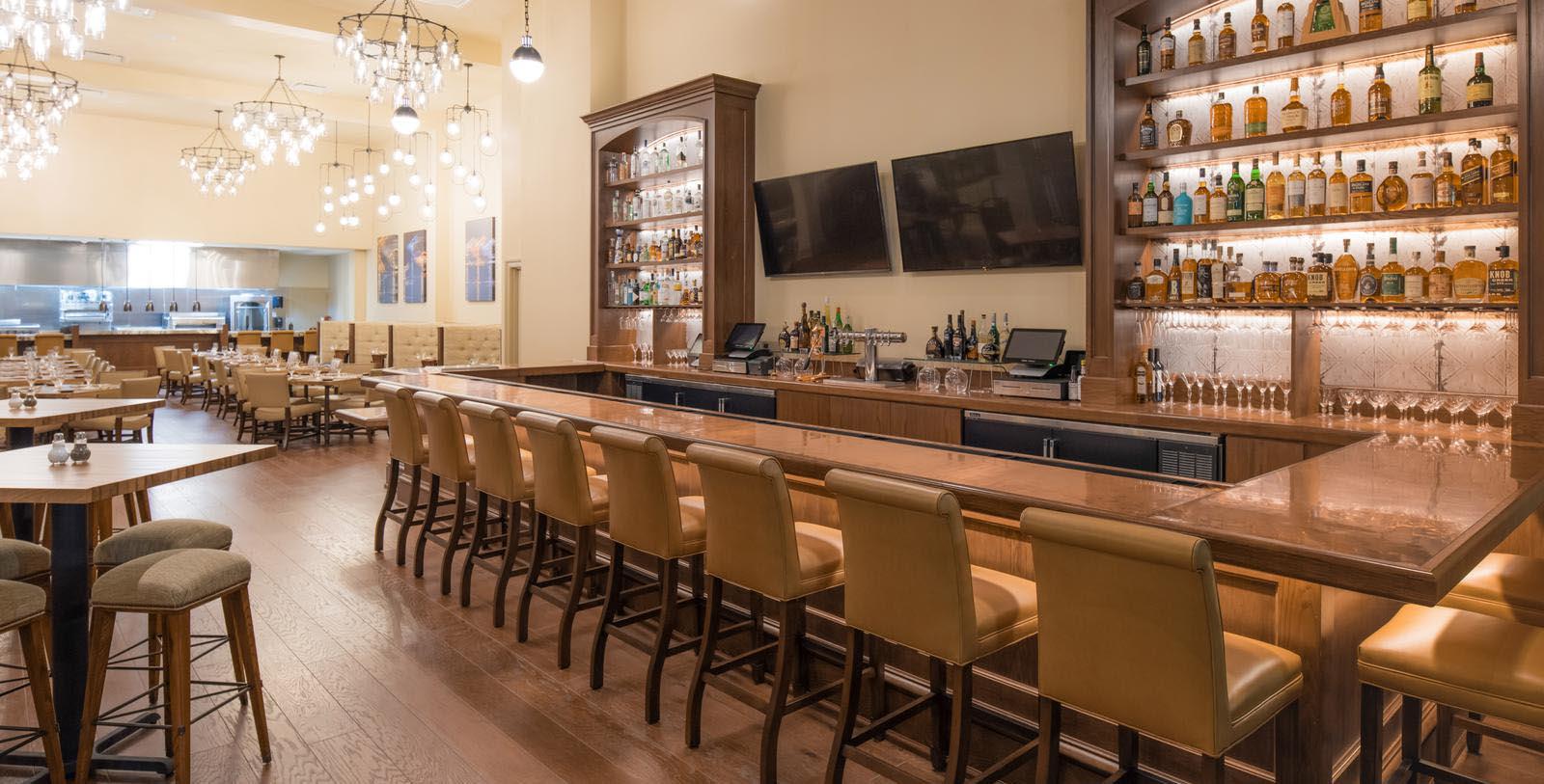 a bar with a row of chairs and a television on the wall