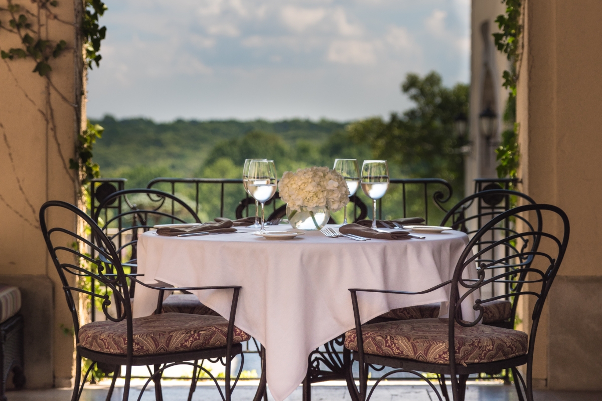 a table set up with wine glasses and a vase of flowers