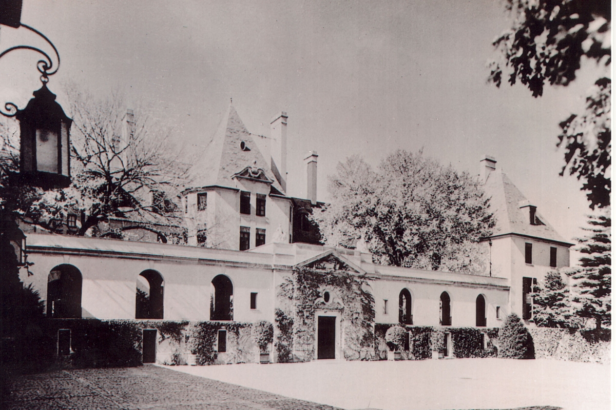 a large white building with trees around it