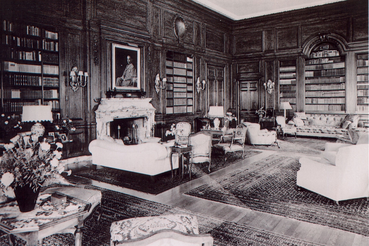 a room with a fireplace and a picture of a man sitting on the couch