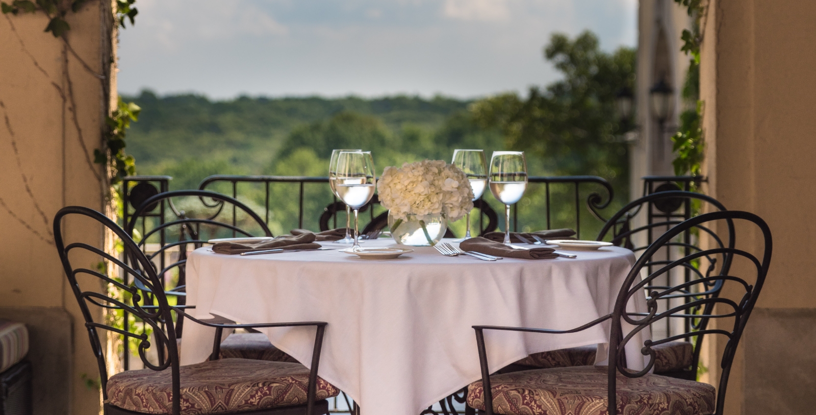a table set with wine glasses and a vase of flowers