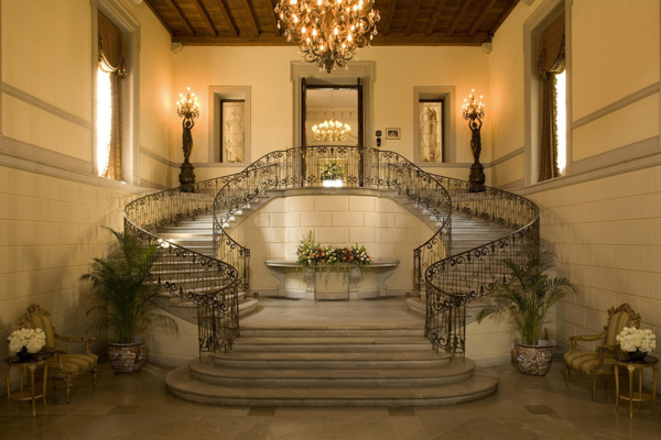 a staircase with chandelier and flowers