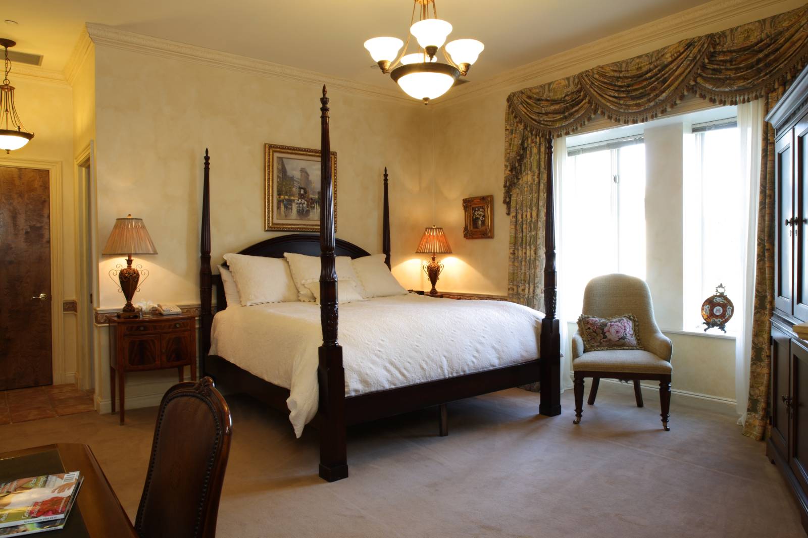 a bedroom with a four poster bed and a chair