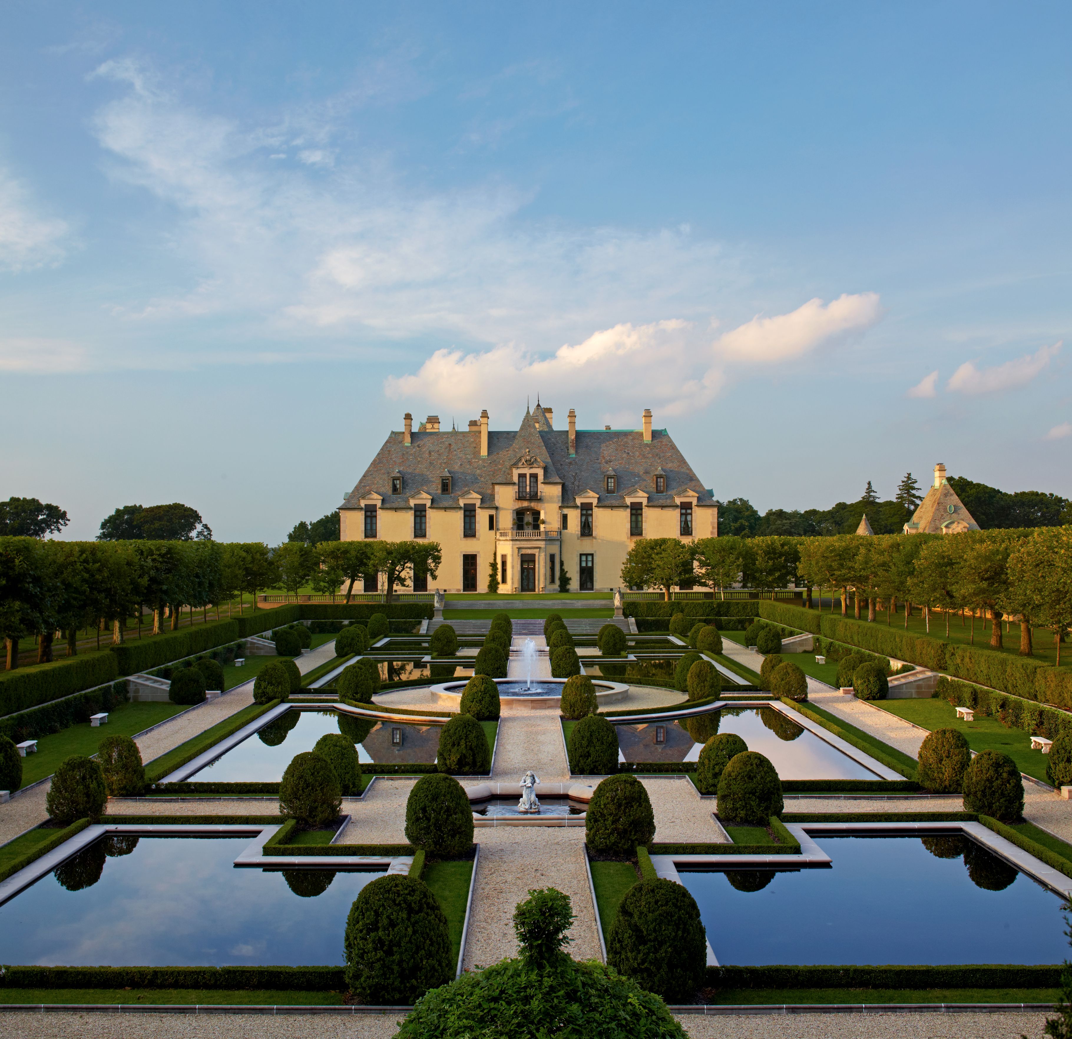 a large formal garden with water fountains and hedges
