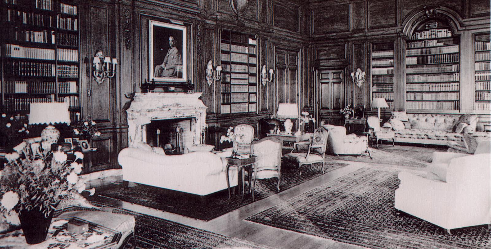 a room with a fireplace and a picture of a man sitting on the top of the fireplace