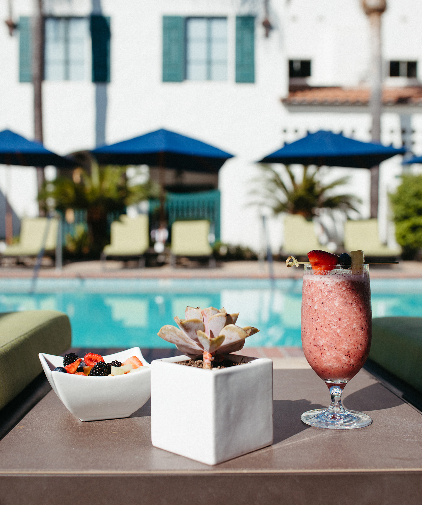 a drink and a bowl of fruit on a table