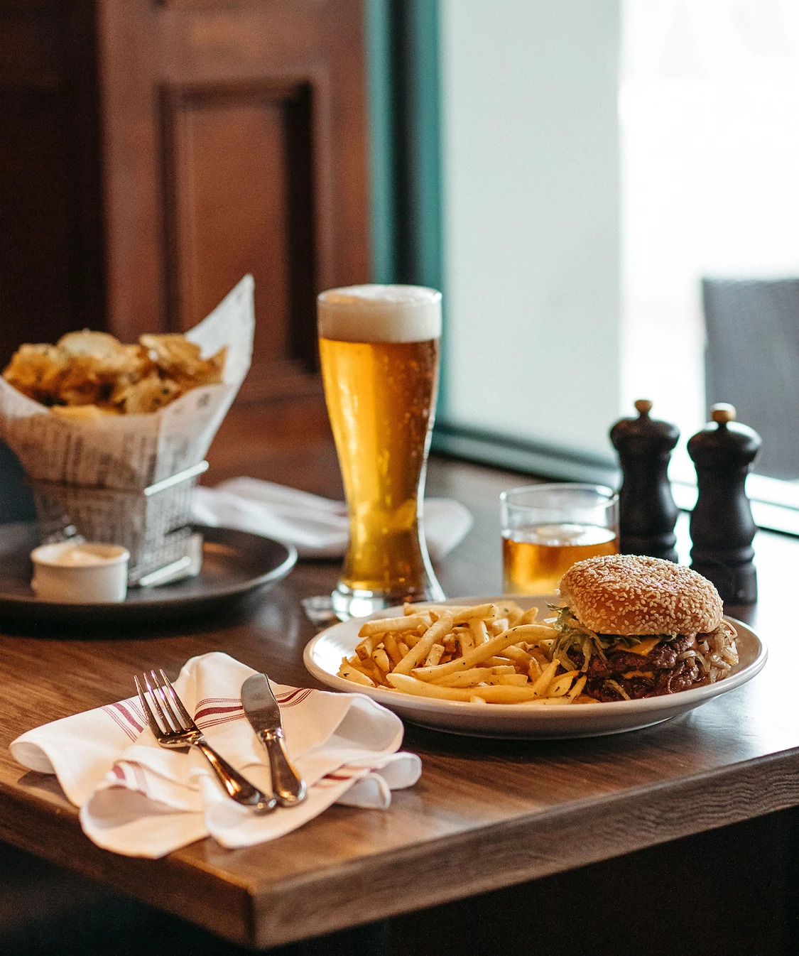 a plate of food and a glass of beer on a table