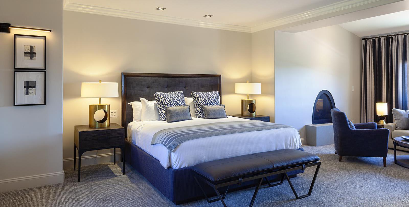 a bed with a bench and lamps