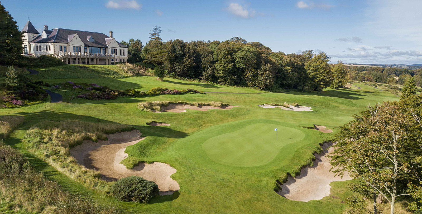 a golf course with a house and trees