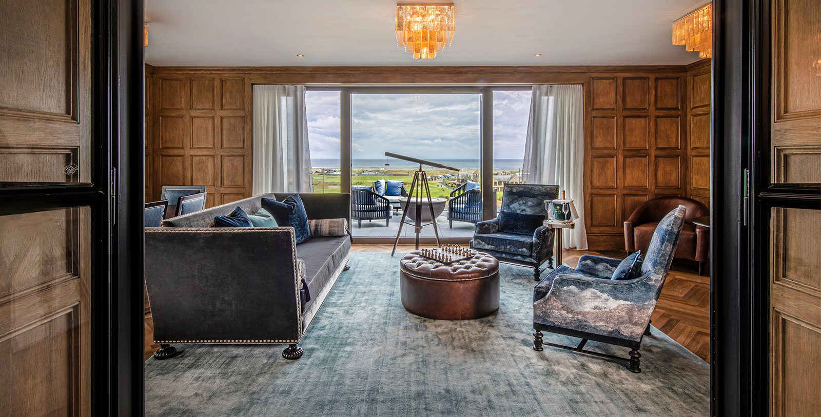 a room with a large window and a couch and chairs