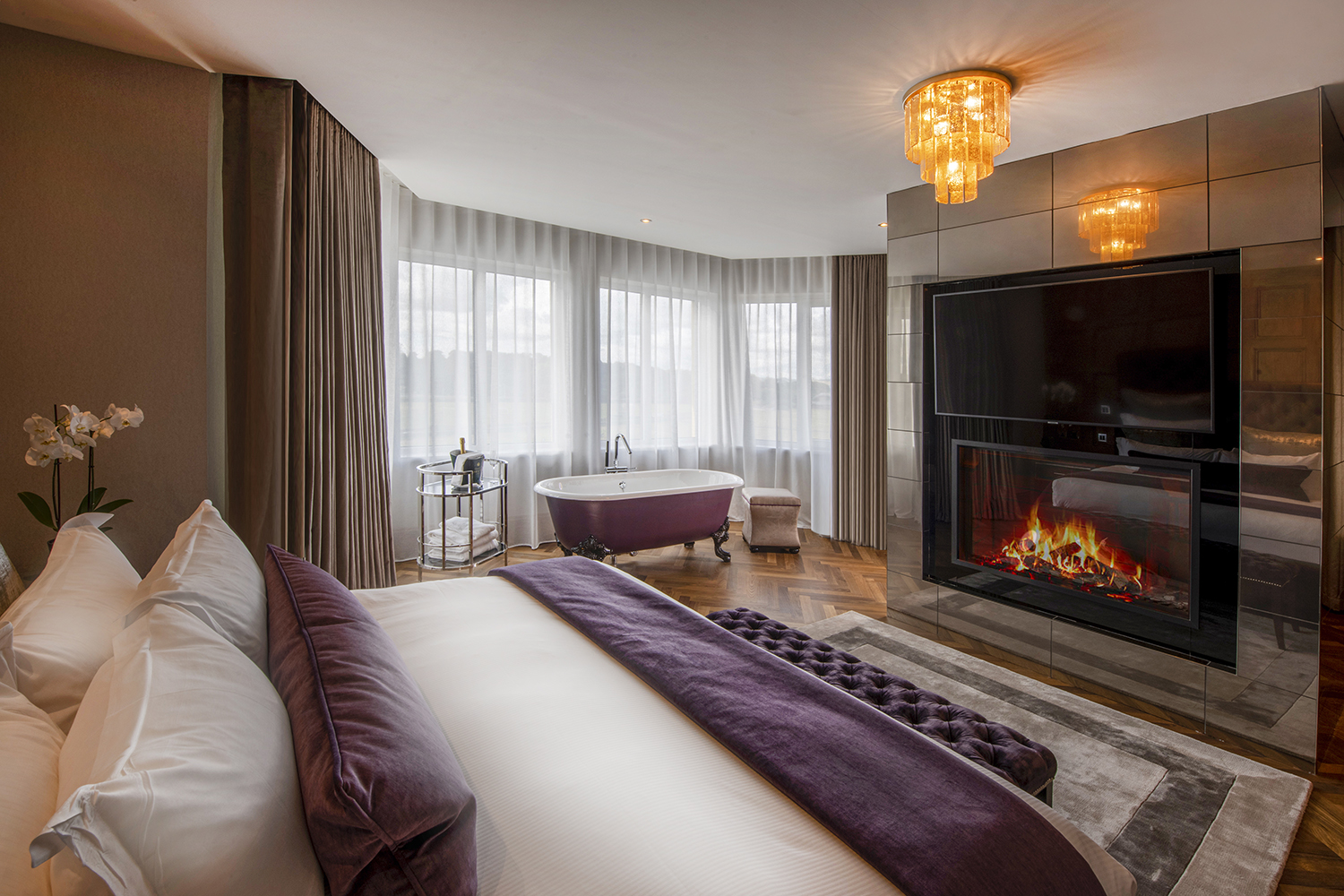 a bedroom with a fireplace and a bathtub