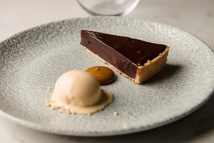 a slice of chocolate pie with ice cream on a plate
