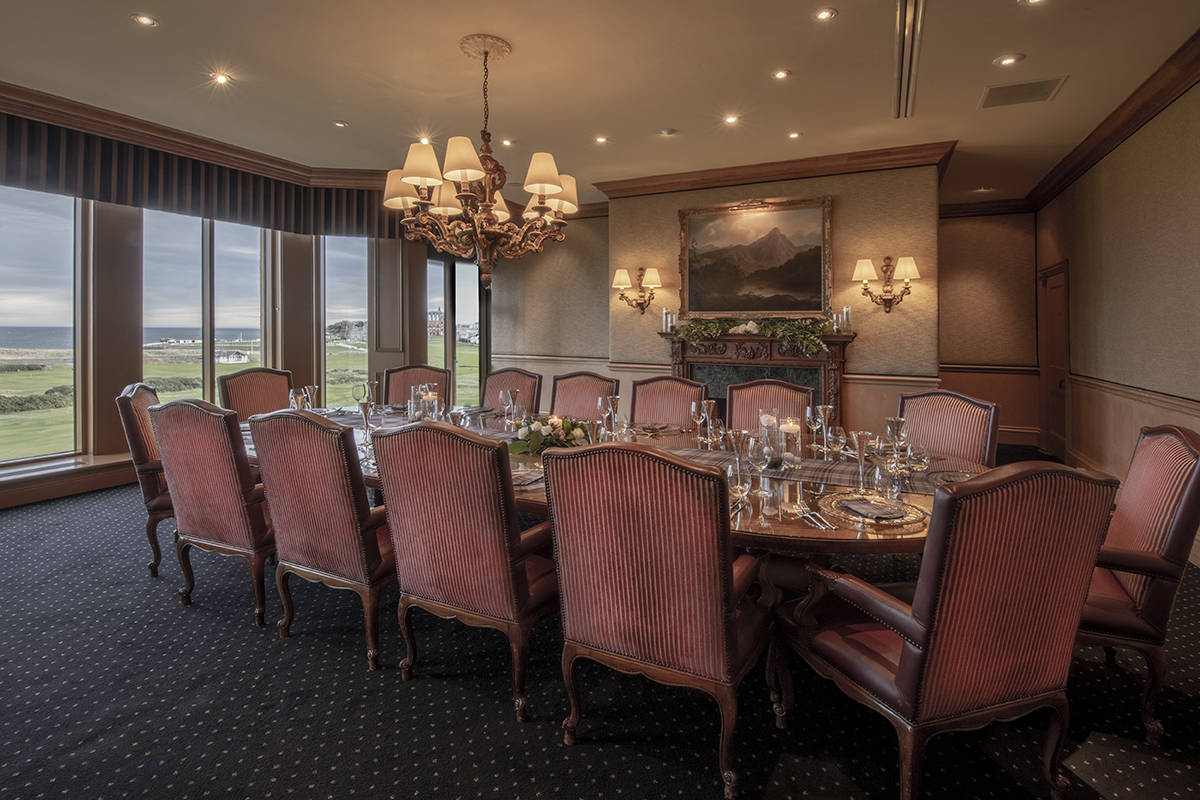 a room with a large round table and chairs