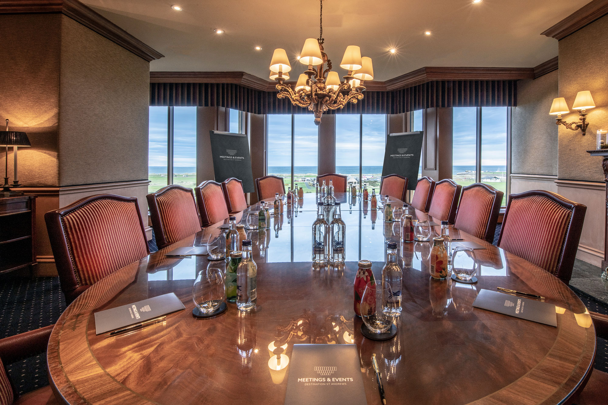 a conference room with a chandelier and chairs