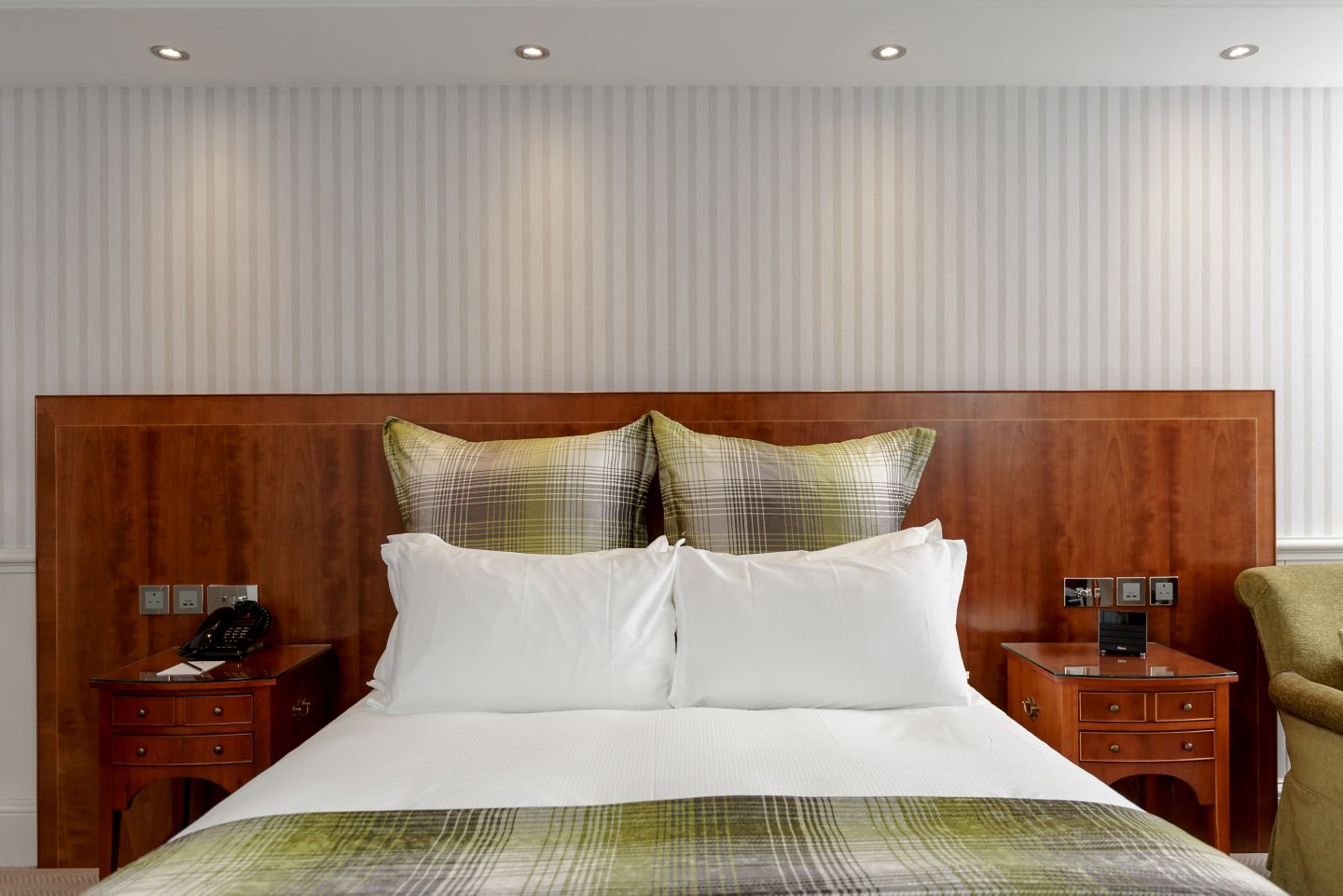 a bed with pillows and a telephone on the side