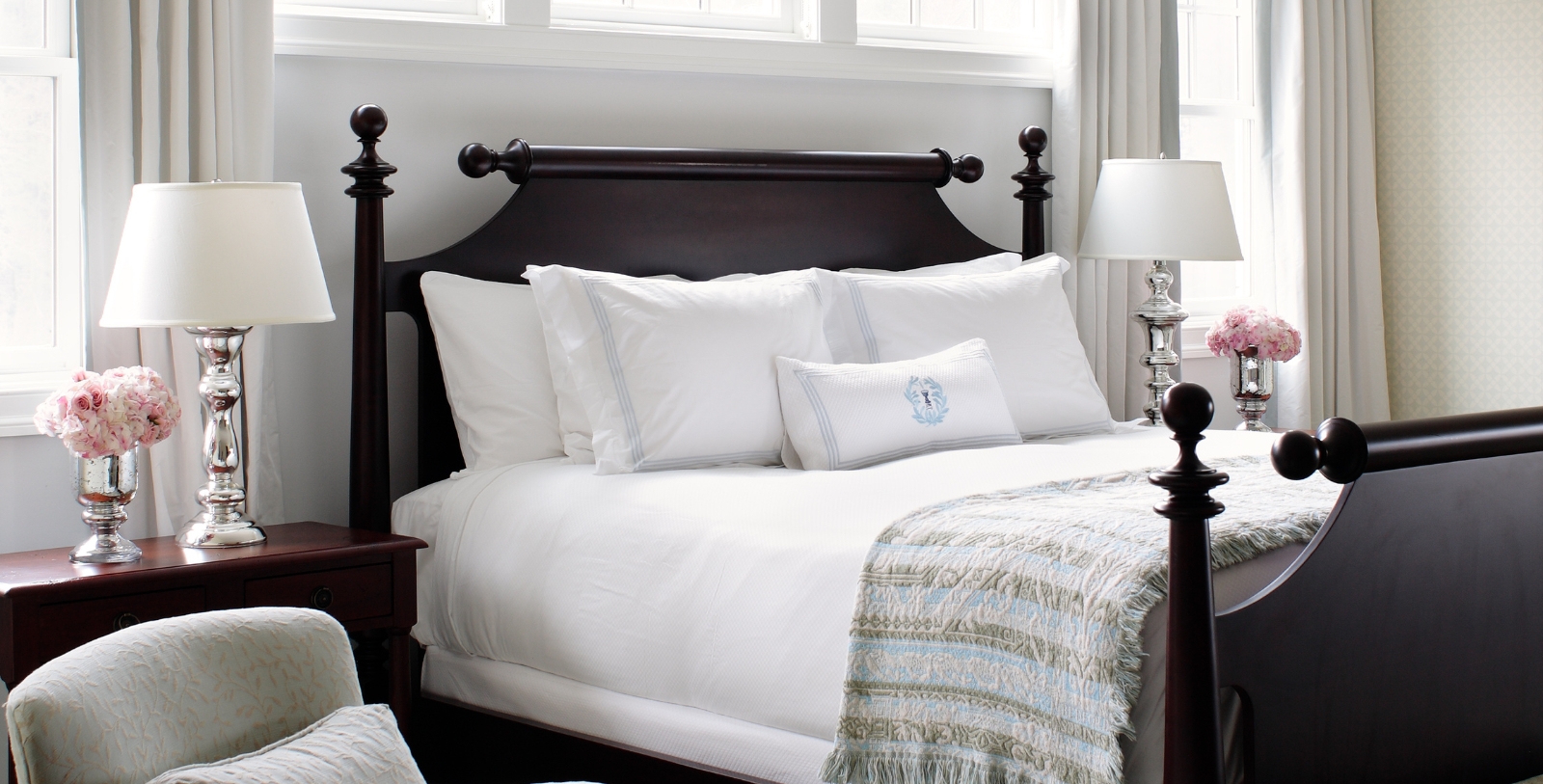 a bed with white sheets and pillows