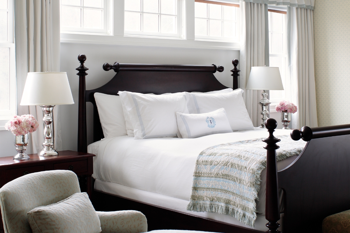 a bed with white sheets and pillows