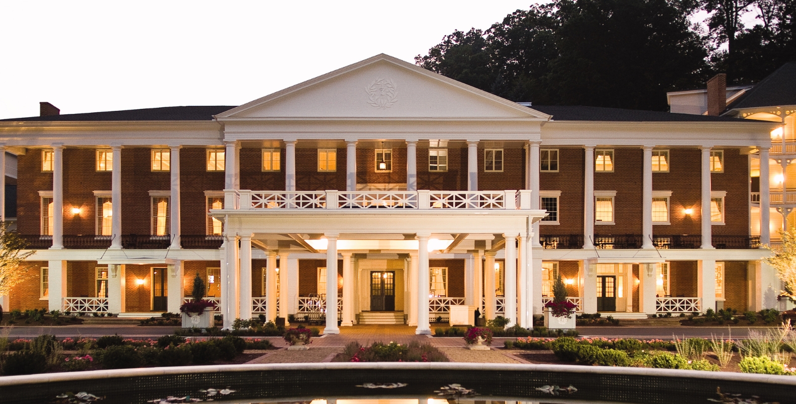a large brick building with columns and a fountain