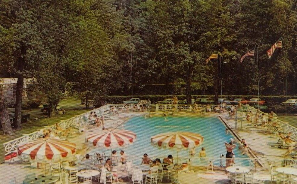 a pool with umbrellas and people around it