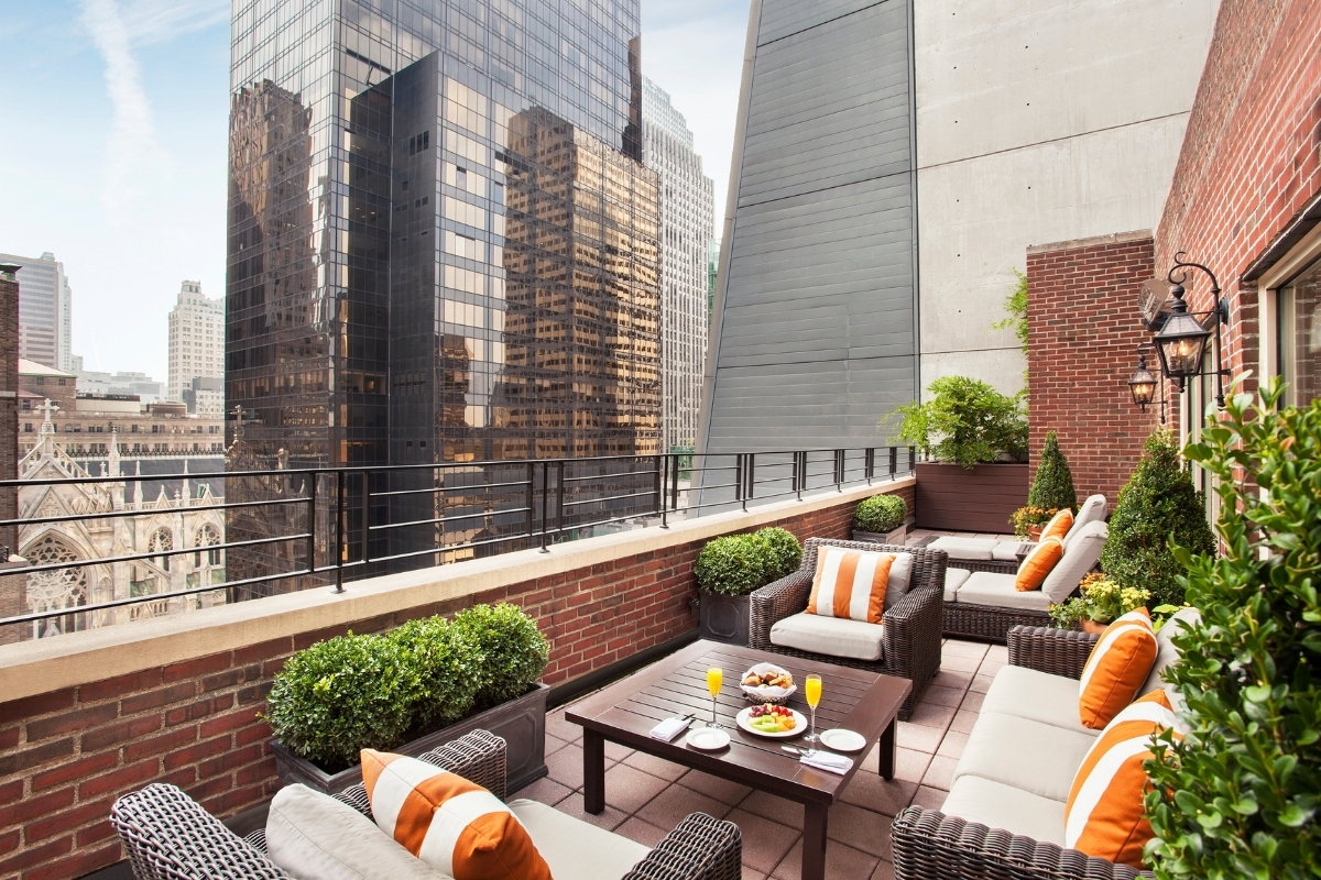 a patio area with a table and chairs and a table with food on it