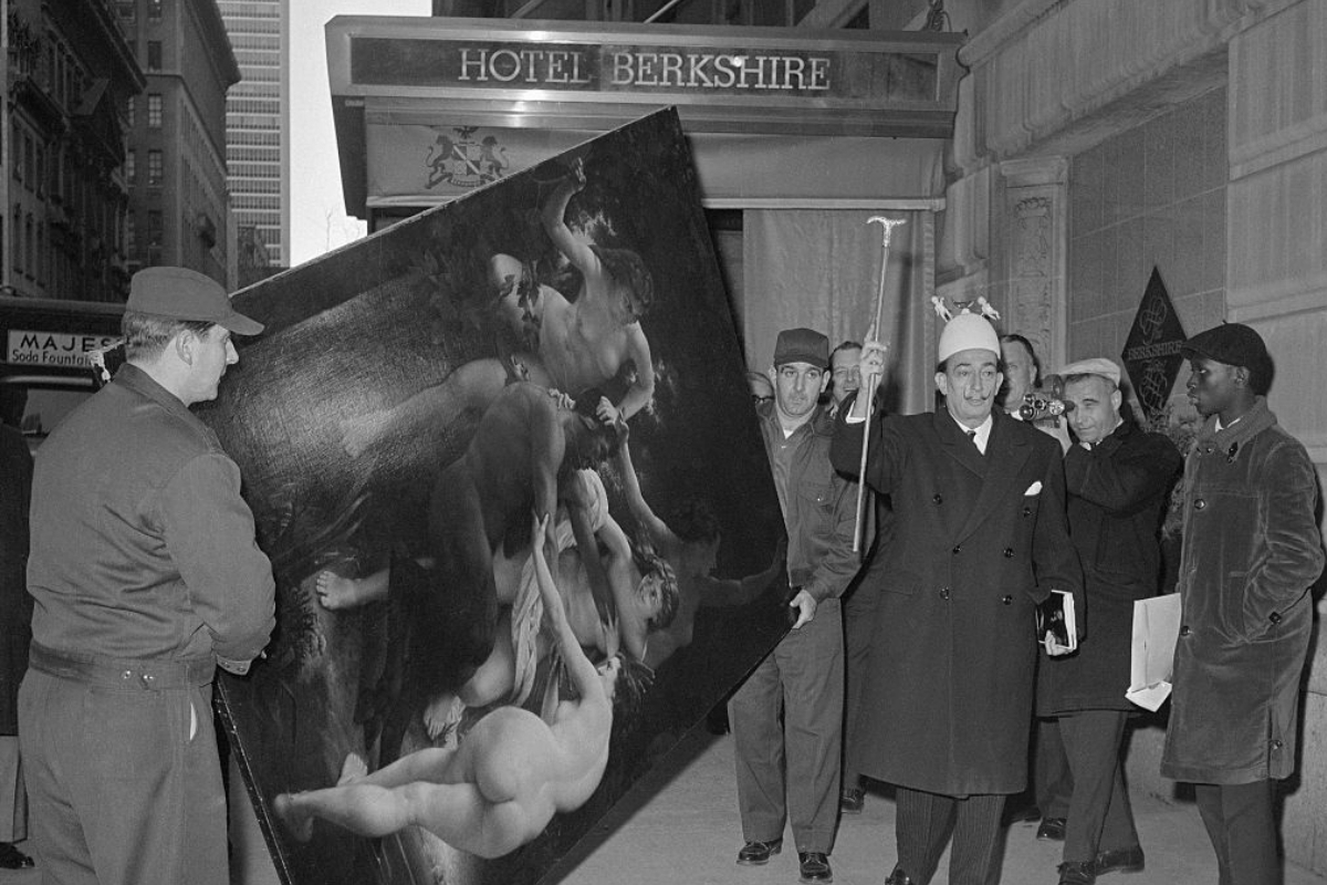 a man holding a large painting