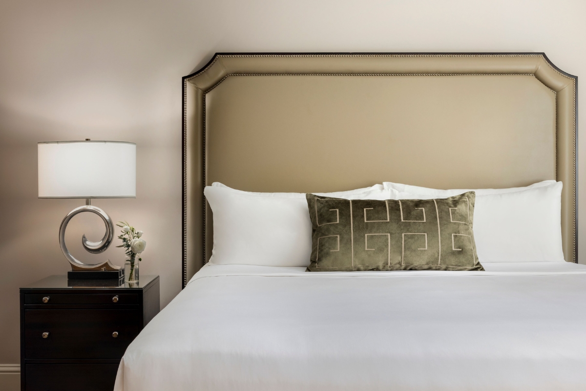 a bed with a lamp and a pillow